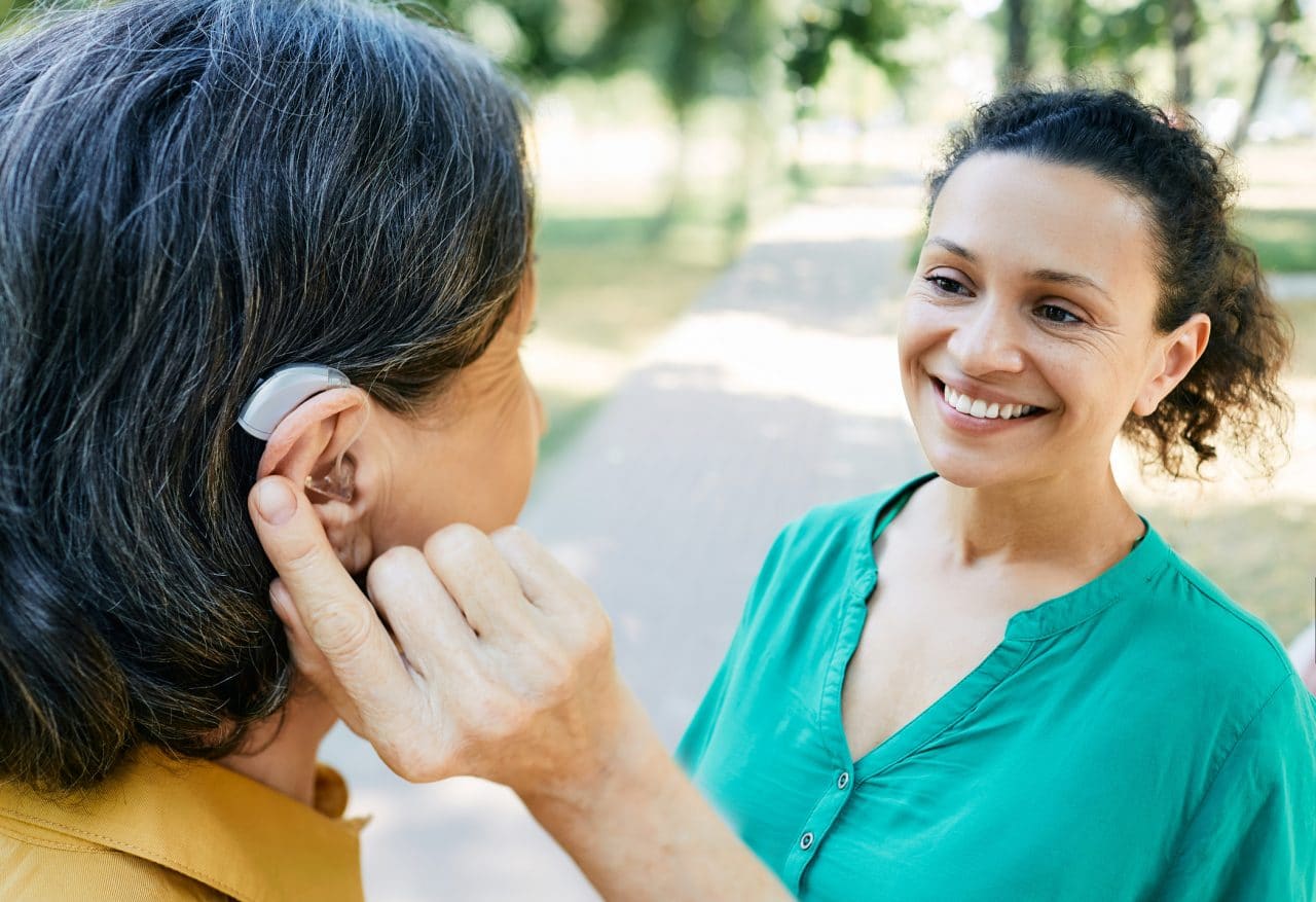 Woman with hearing aid talking to her friend.