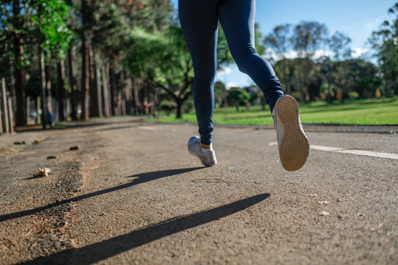 Woman jogging outside on an open road.