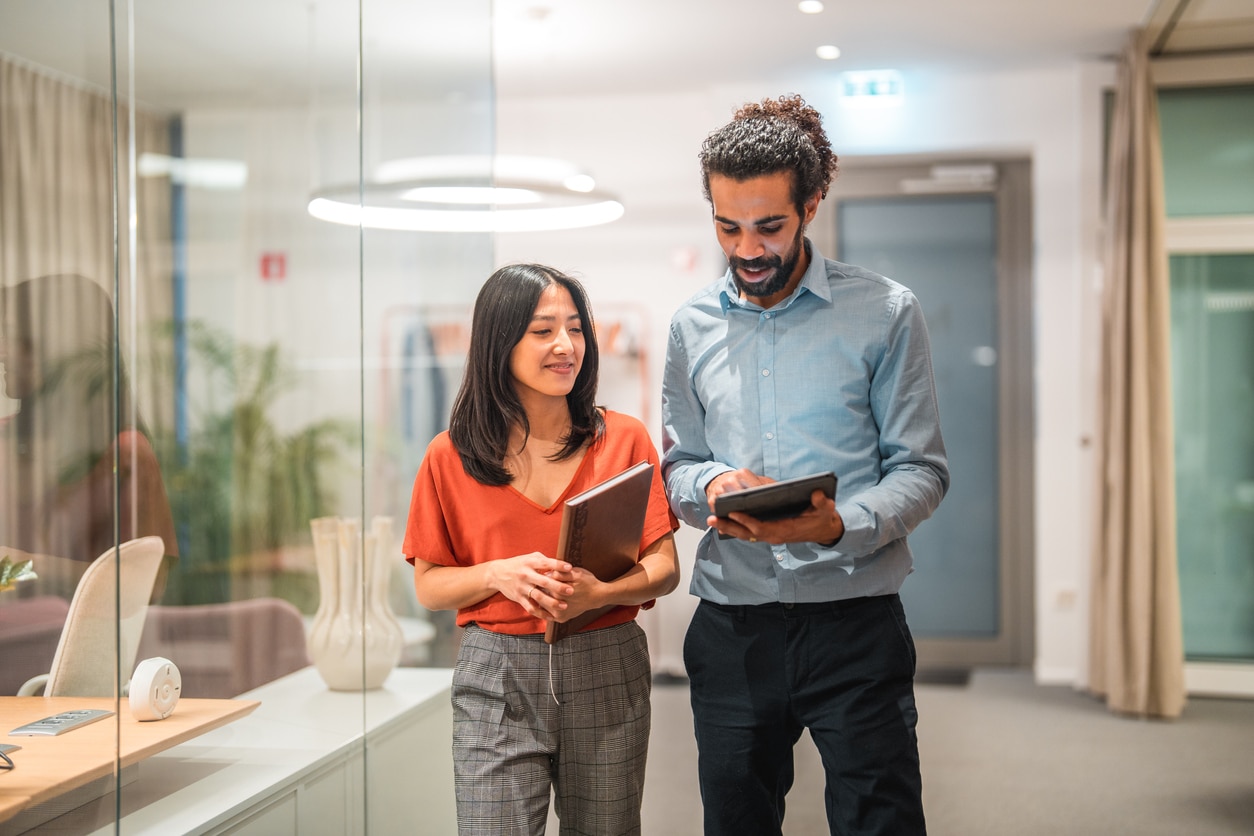 Two coworkers looking at a tablet together