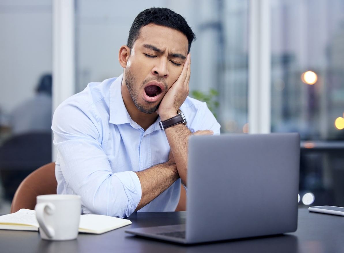 Man yawning in front of his computer.