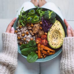 Woman holds bowl of healthy foods