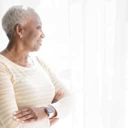 Woman with hearing aid looks out window