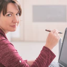 Woman wearing a hearing aid using her laptop